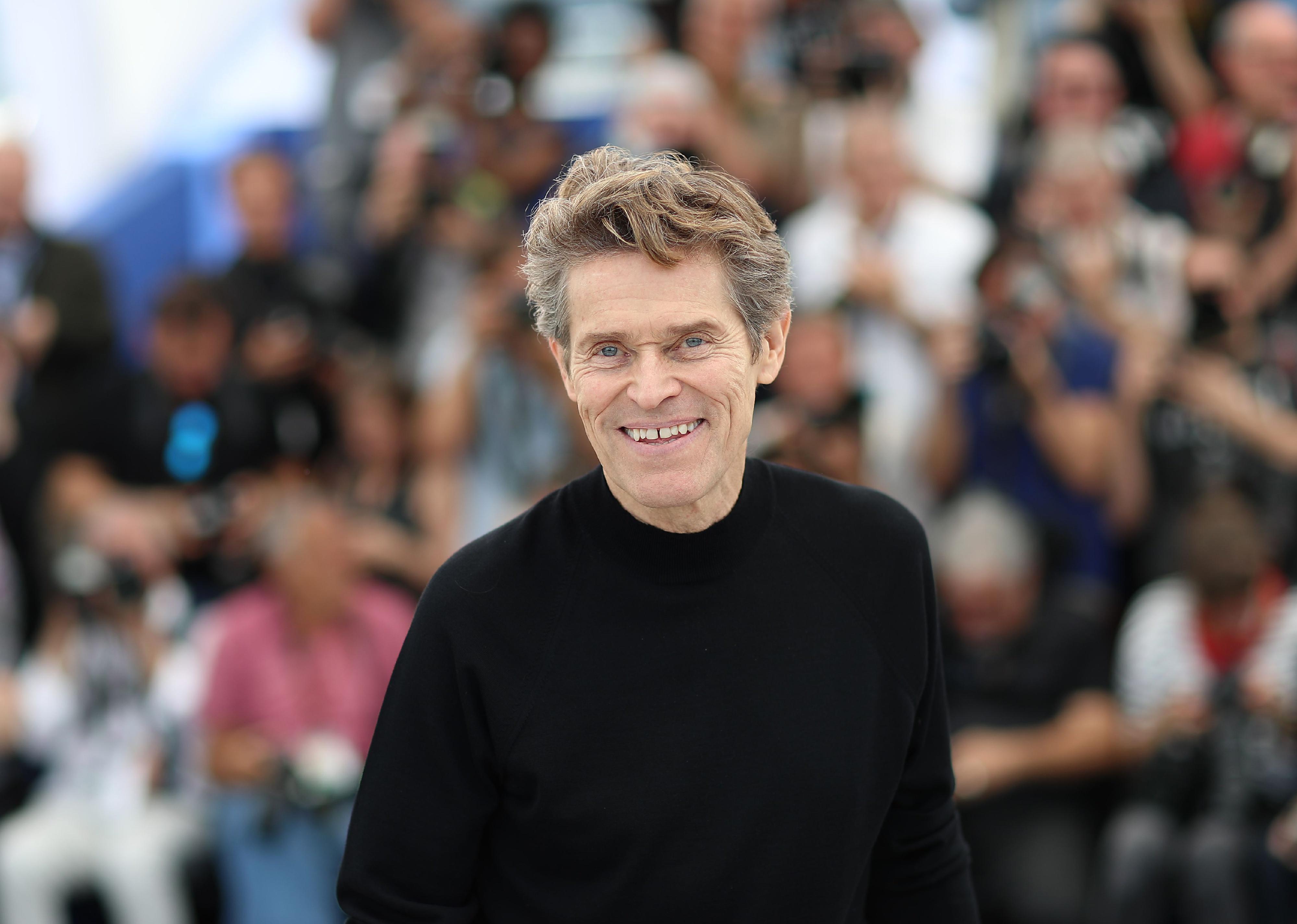 Willem Dafoe in a black shirt.