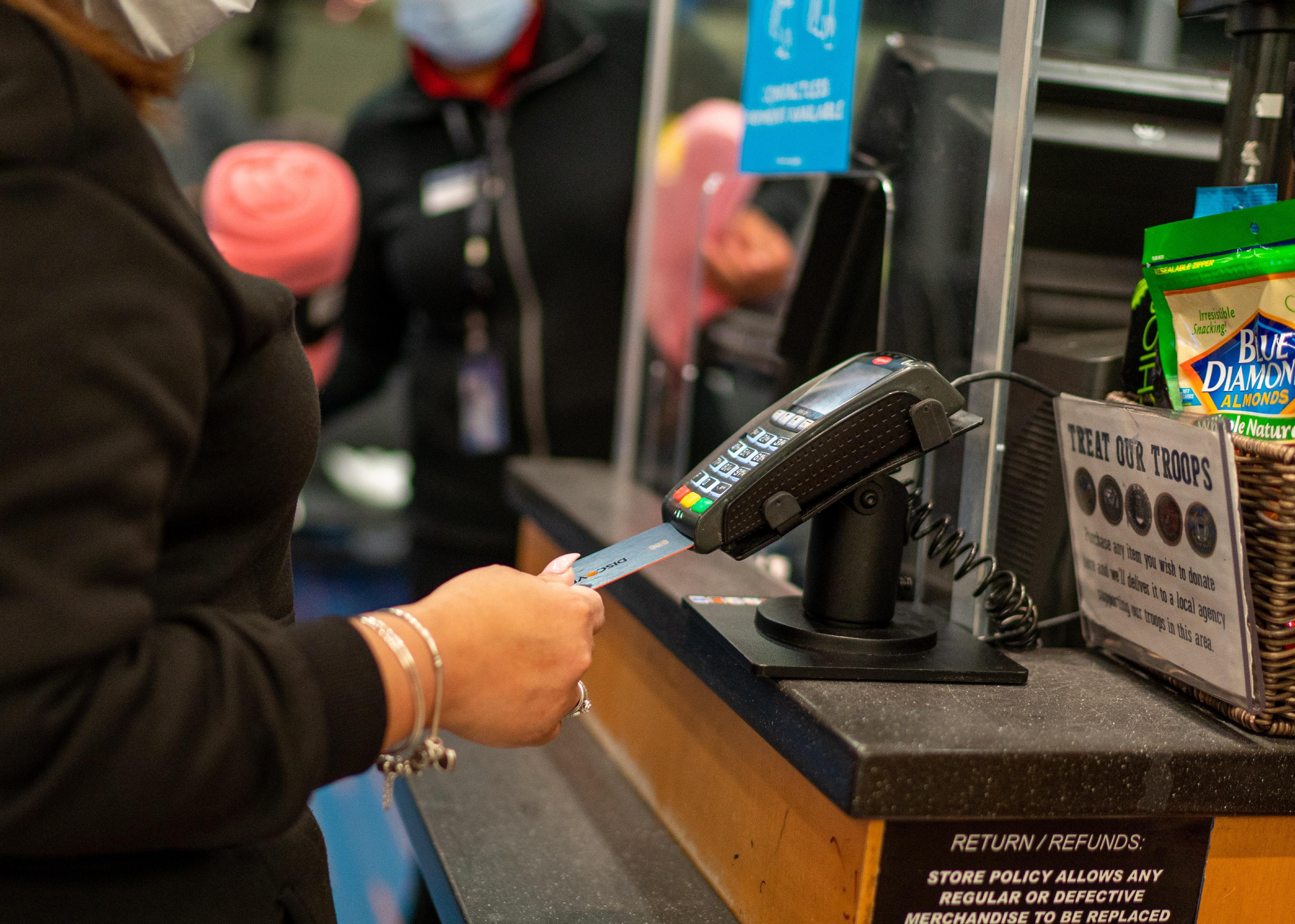 A person checking out at a desk with a credit card.