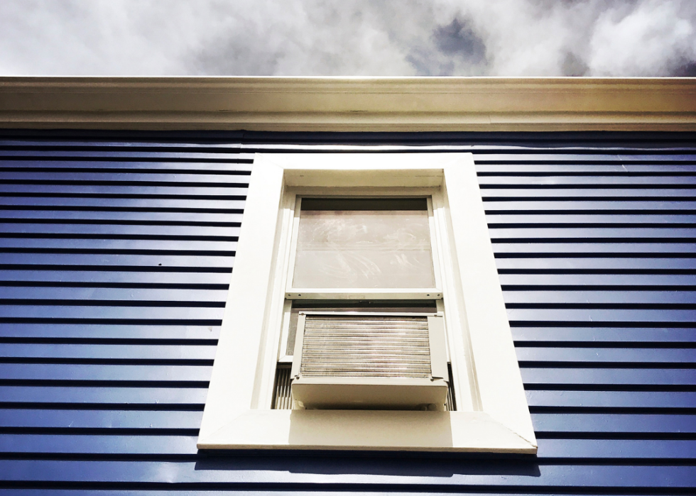 Window unit in a blue-sided building.