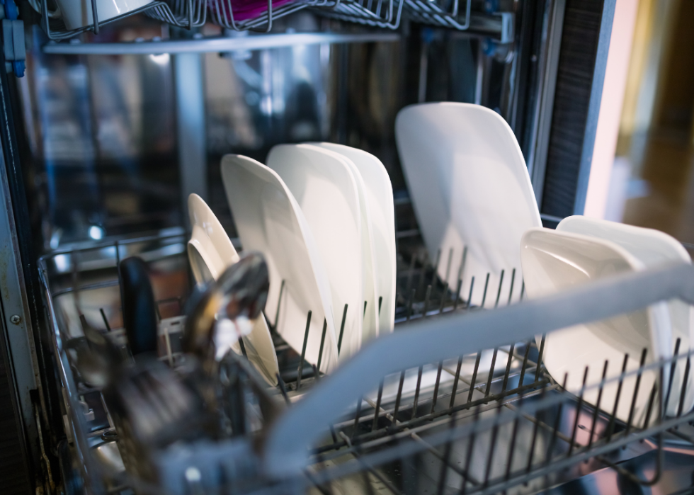 Plates and silverware inside a dishwasher.