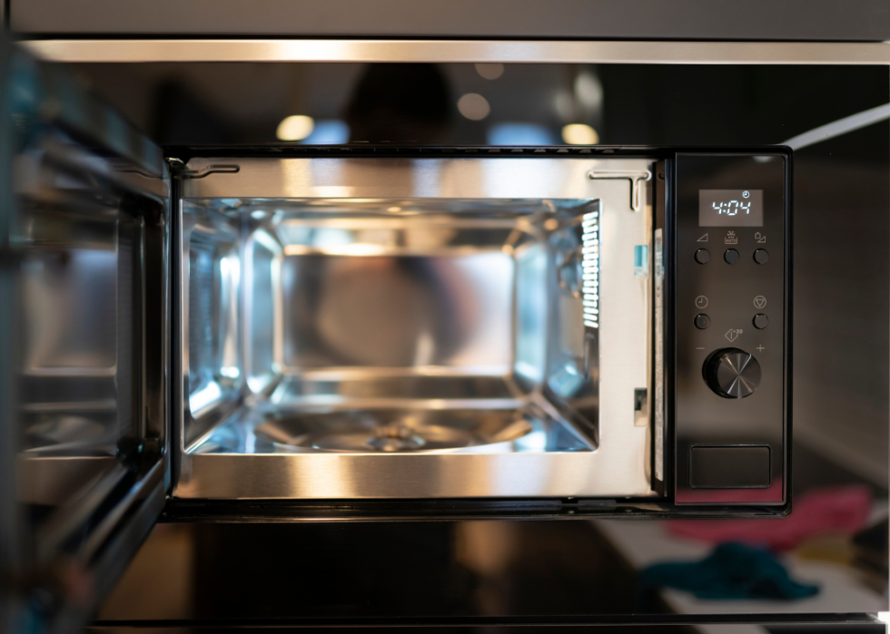Black microwave with door open and silver inside.