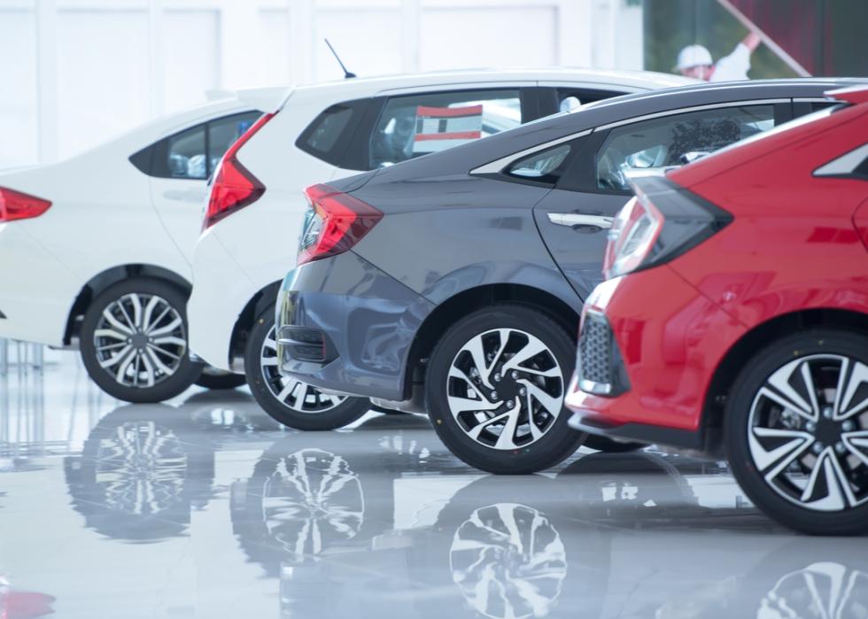 Row of cars in a dealership showroom.