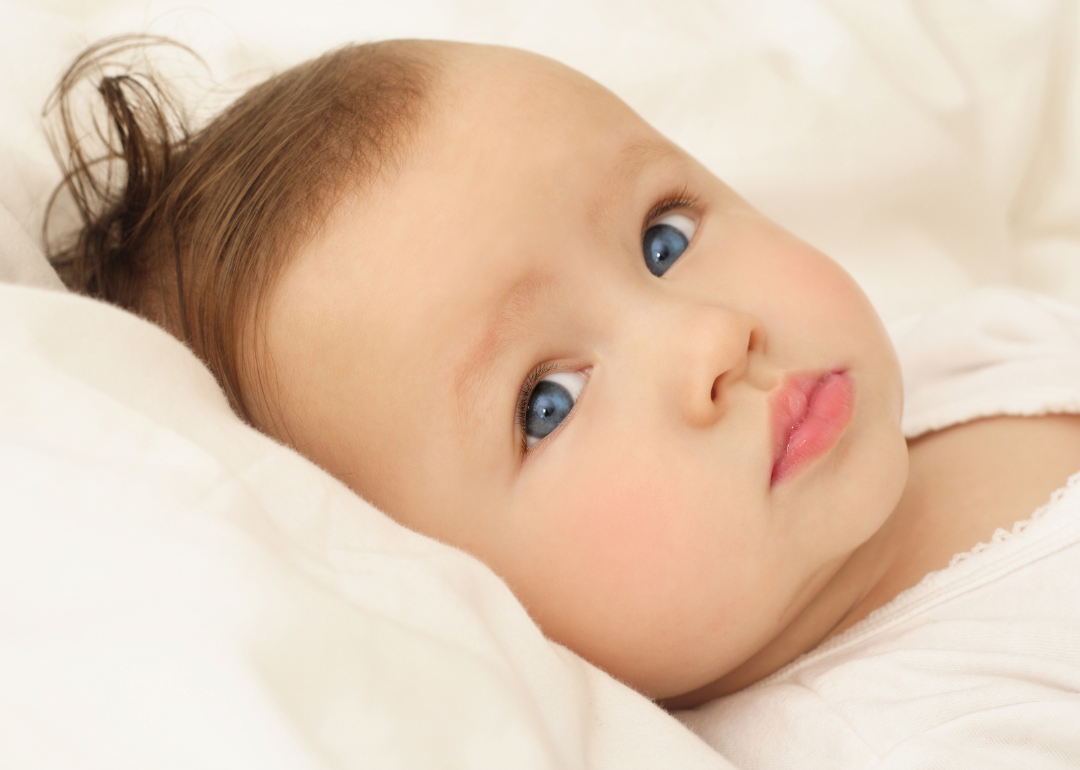 A blue-eyed baby lying down.
