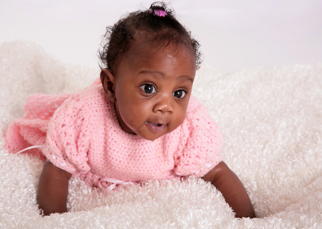 A baby in a pink knitted outfit.