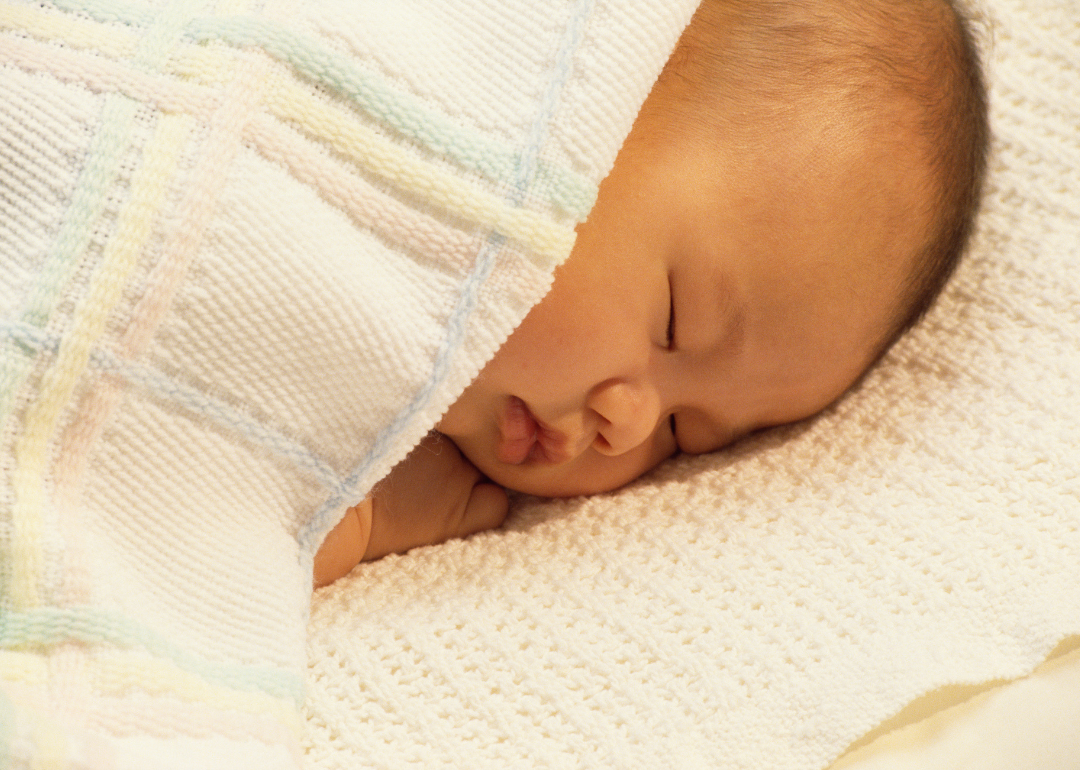 A sleeping baby wrapped in a blanket.