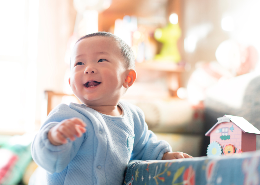 A baby playing in a blue suit.