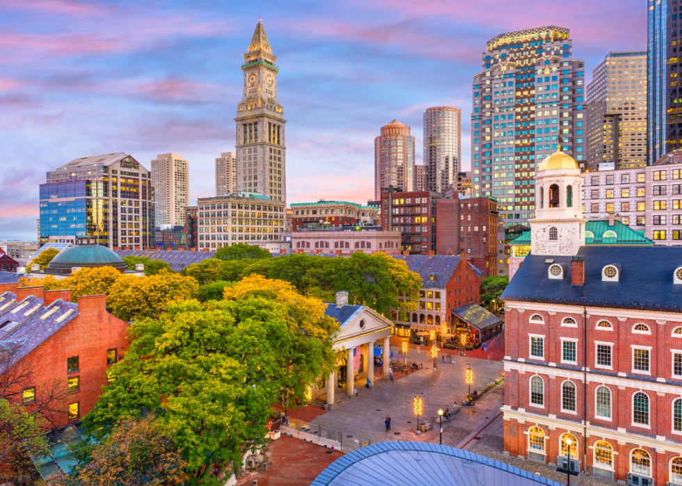 A historic brick downtown square with big buildings in the background at twilight.