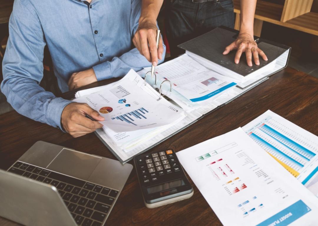 Two people going over graphs and paperwork.