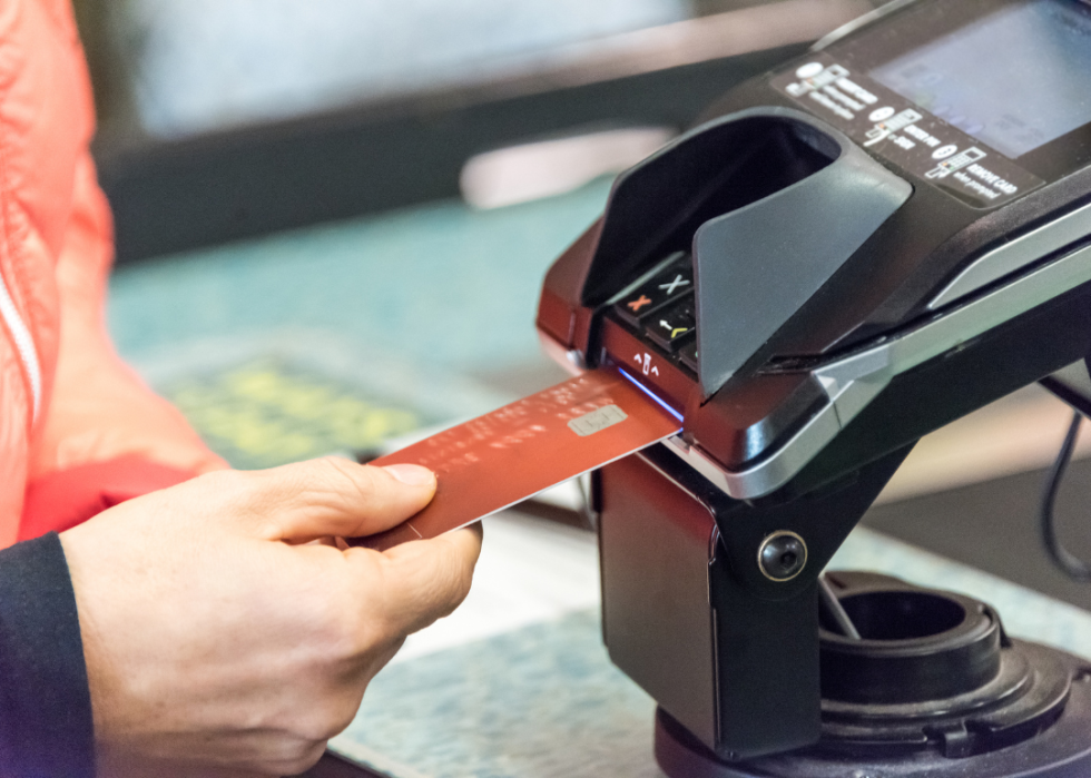 Inserting a credit card into a machine to pay.