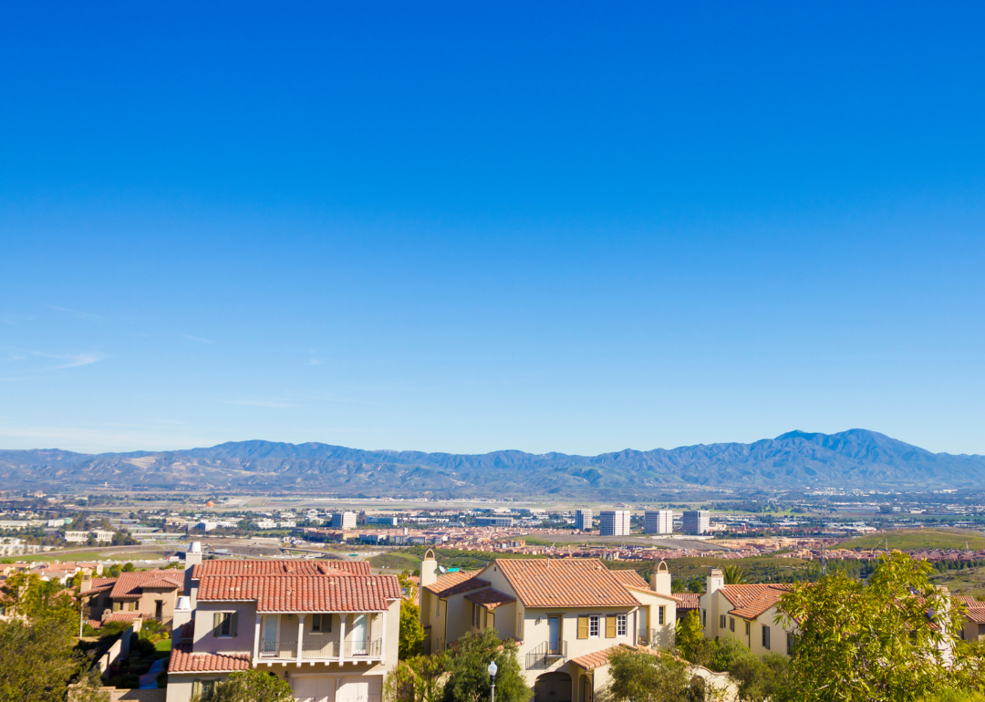 Large homes with buildings and mountains in the background.
