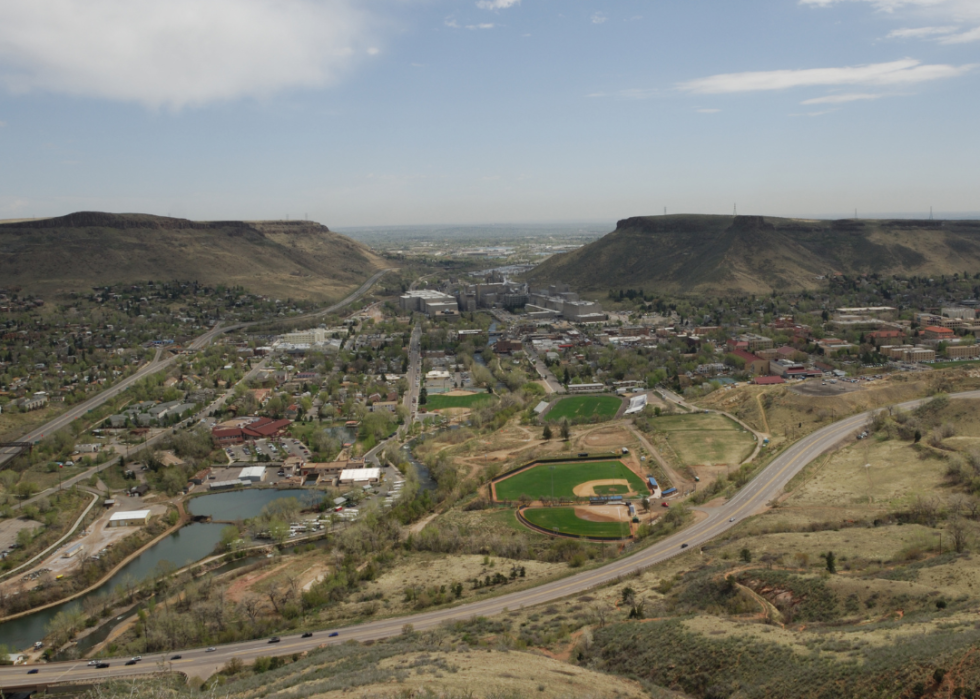An aerial view of a hilly area with homes and a baseball diamond.