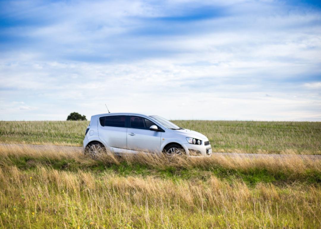 A silver Chevrolet Sonic on a country road.