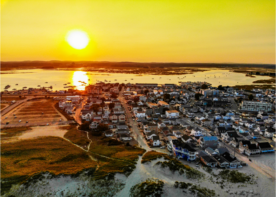 An orange sunset over homes on the water.
