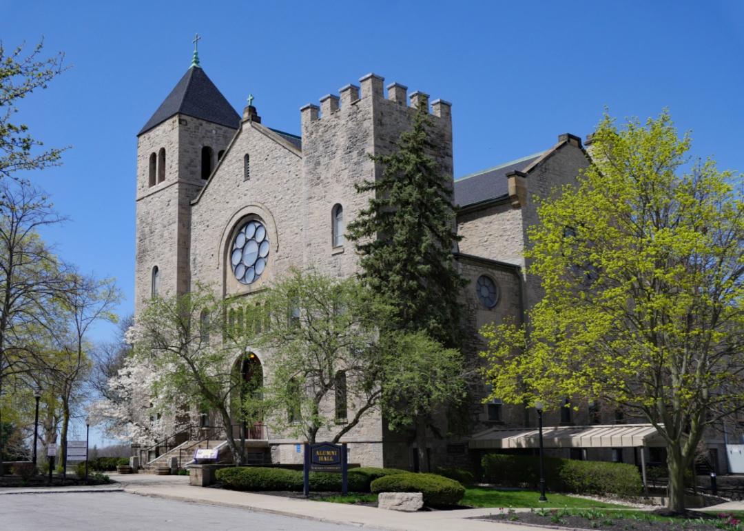 A traditional historic gray stone building with a circular window at the top