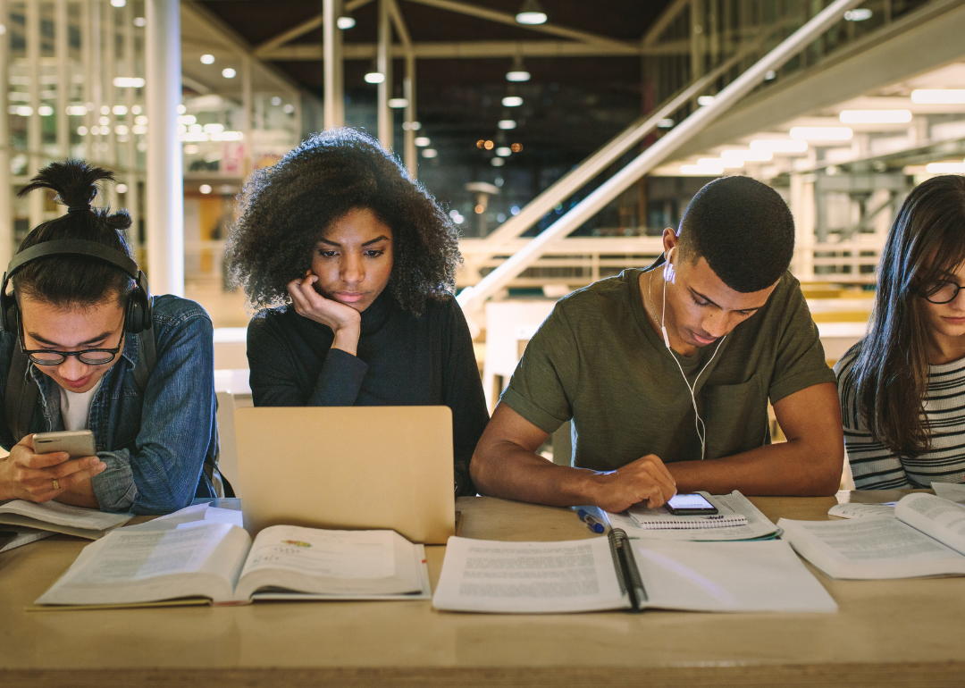 A row of students studyig at a library