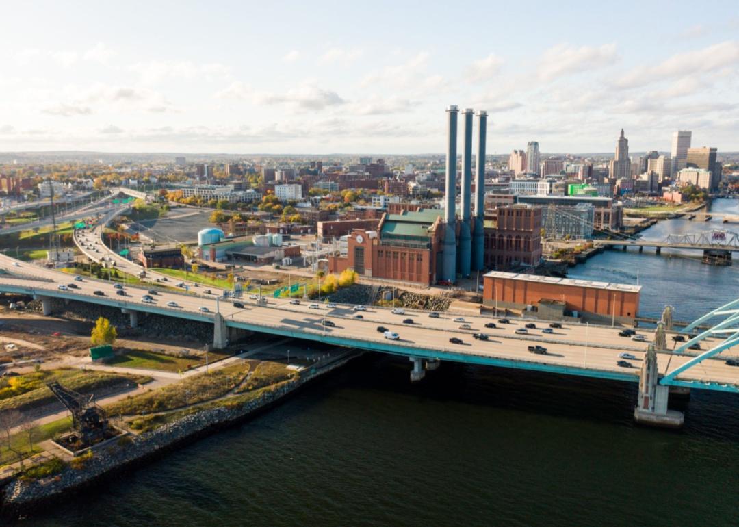 The Manchester Street Power Station smokestacks in the city skyline near the river and interstate highway in Providence, Rhode Island.