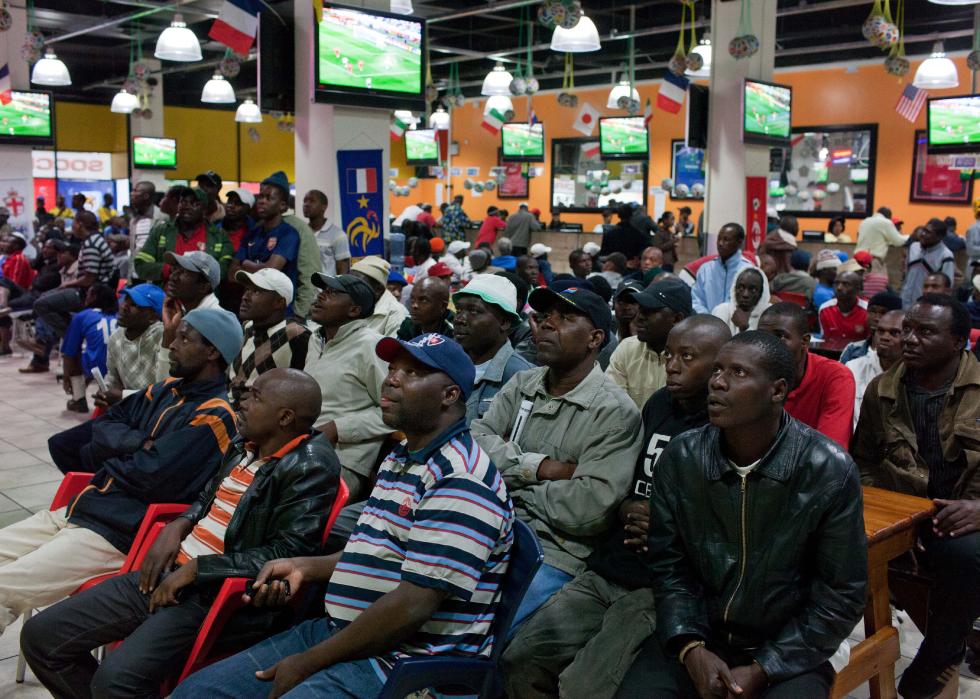 People who bet on the World Cup watch the game at a betting shop