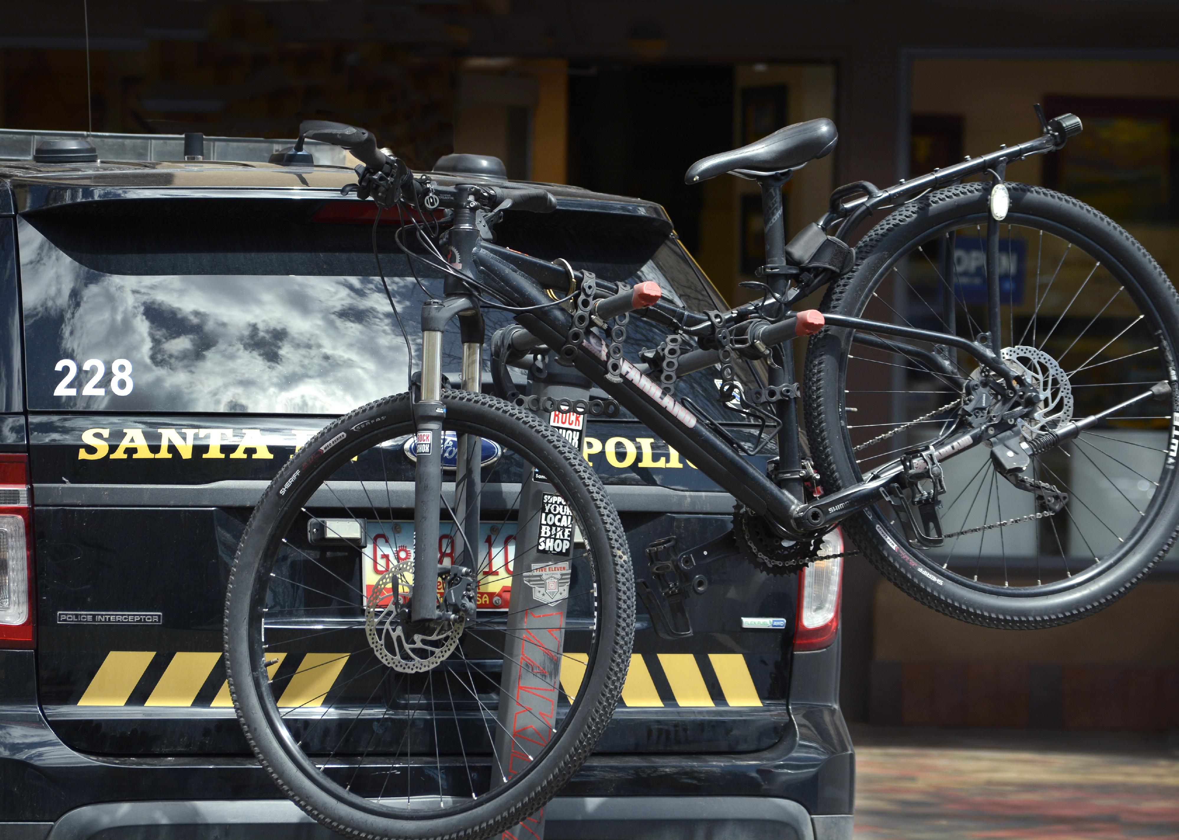 A policeman's bicycle attached to the rear of a police car in Santa Fe, New Mexico.