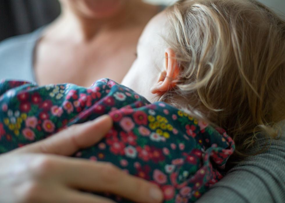 Back view close up of child on mothers chest