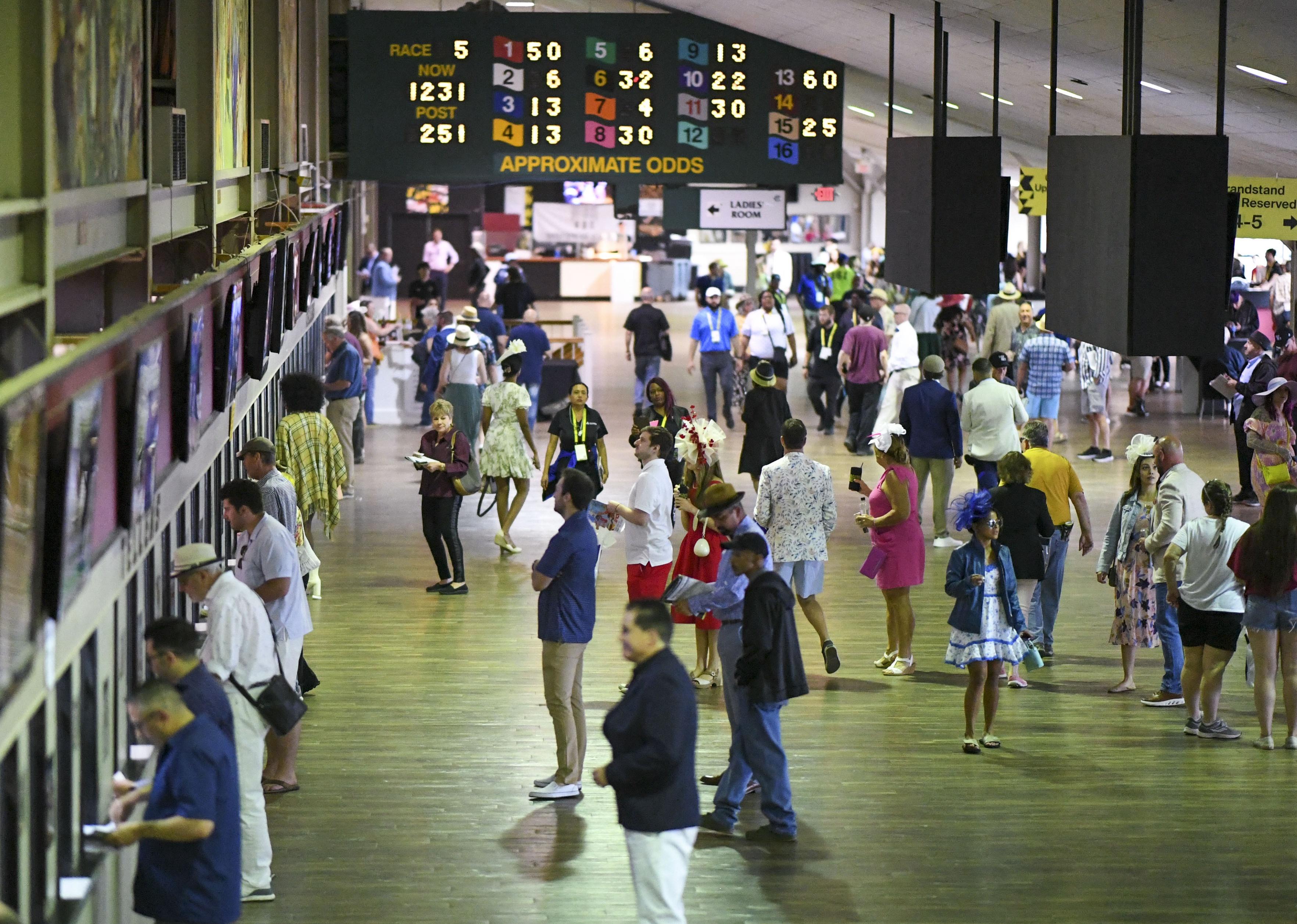 Race fans line up to place their bets at Pimlico Race Course.