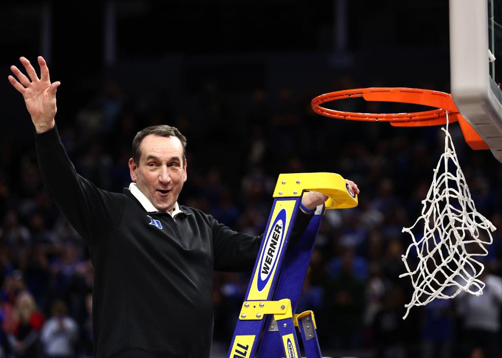 Mike Krzyzewski climbs the ladder to cut down the net 