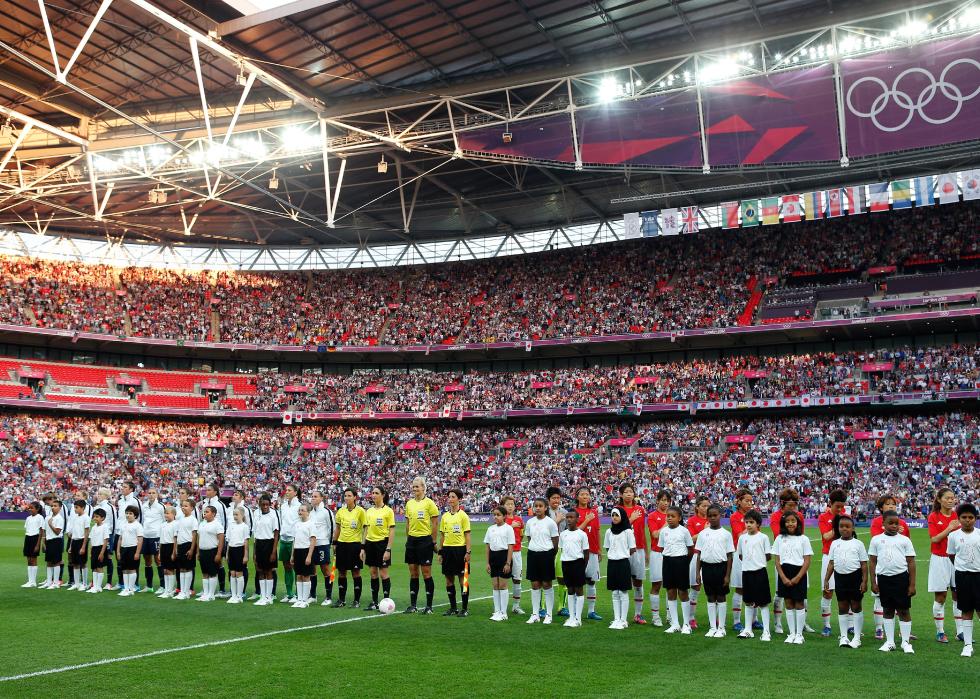 The United States and Japan teams stand during the national anthem