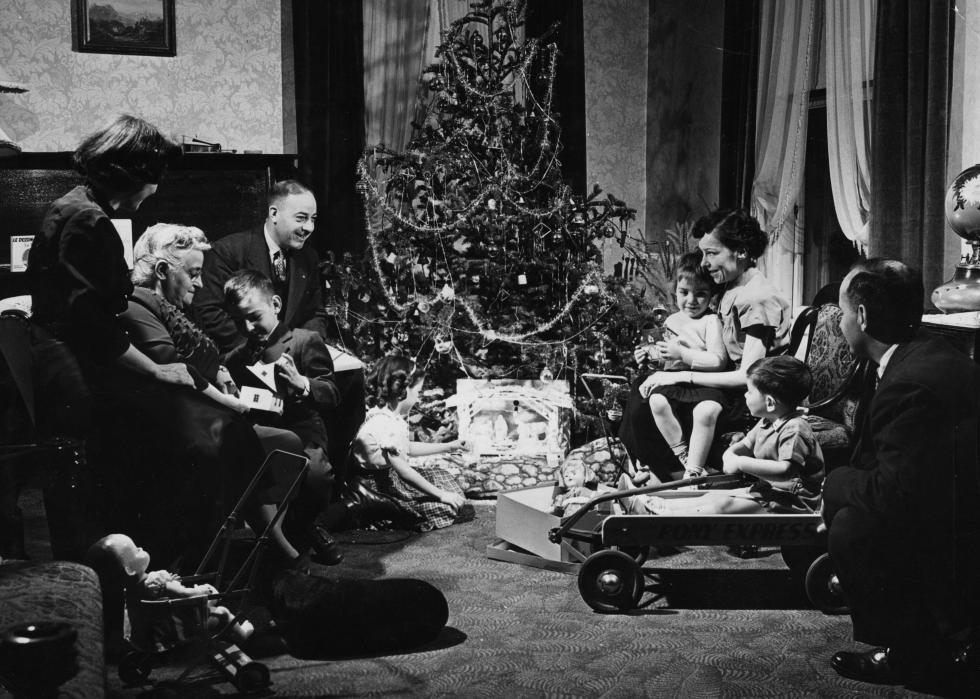 Family opening presents around a tree at Christmas.