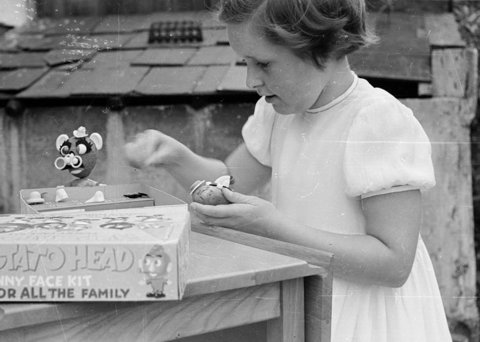 A child plays with a Mr. Potato Head toy.