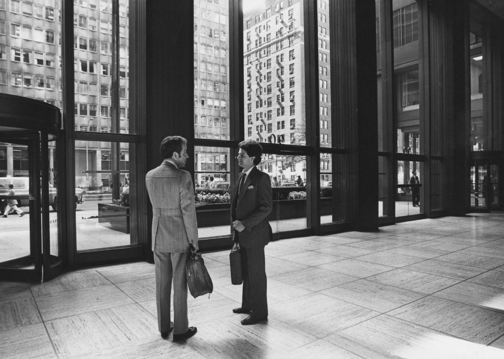 Two men talking in the reception area of a large building