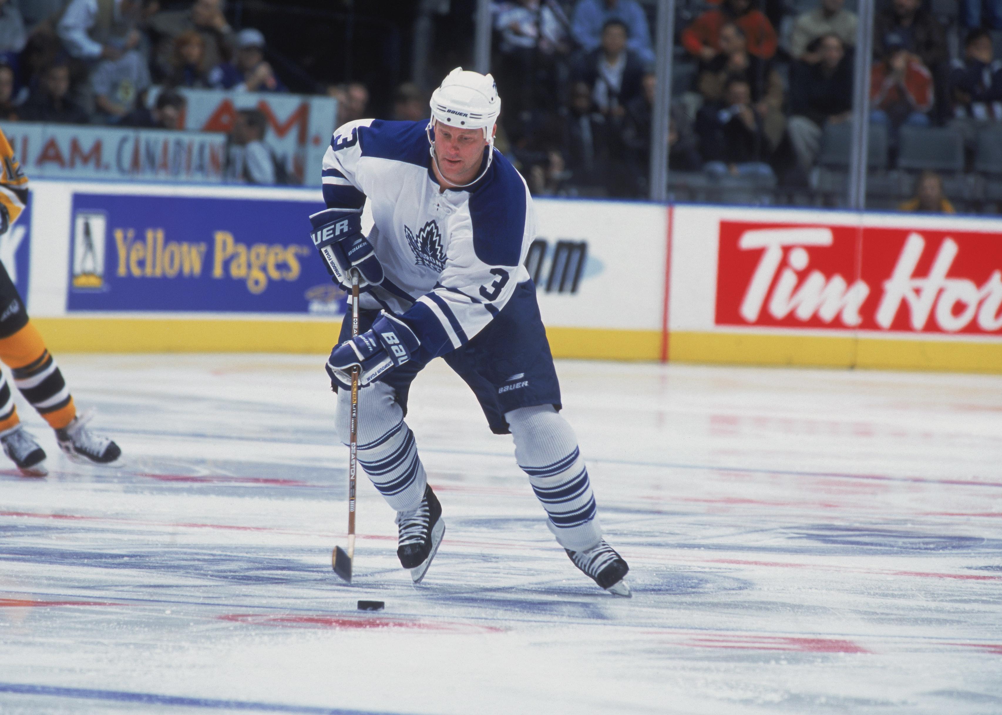 Dave Manson controls the puck on the ice during a game.