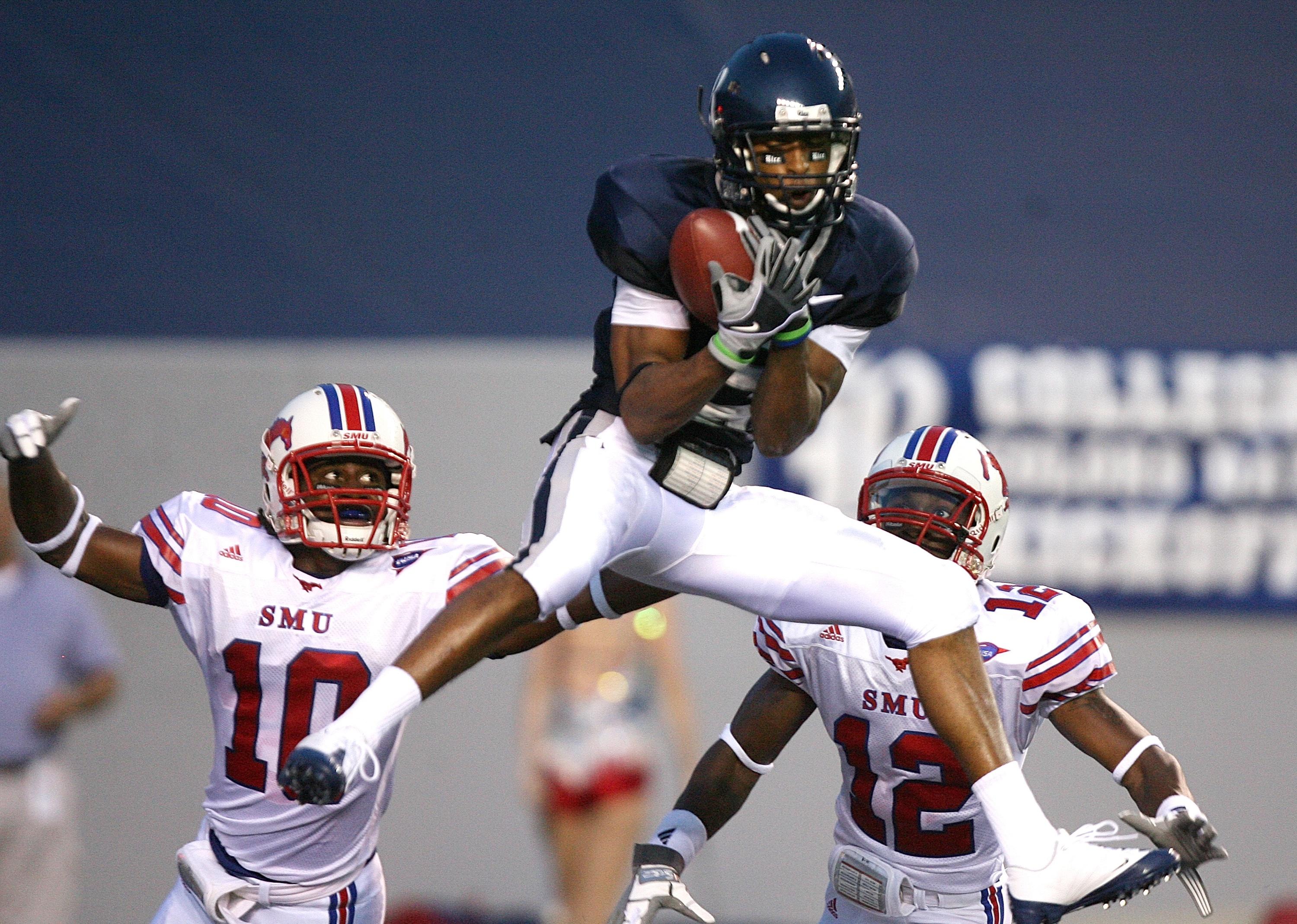 Patrick Randolph of Rice University goes up between defensive backs Rock Dennis and Derrius Bell.