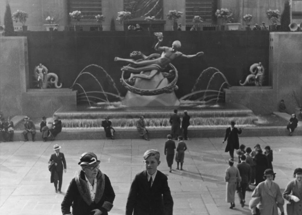 People walking around the fountain at Rockefeller Center.