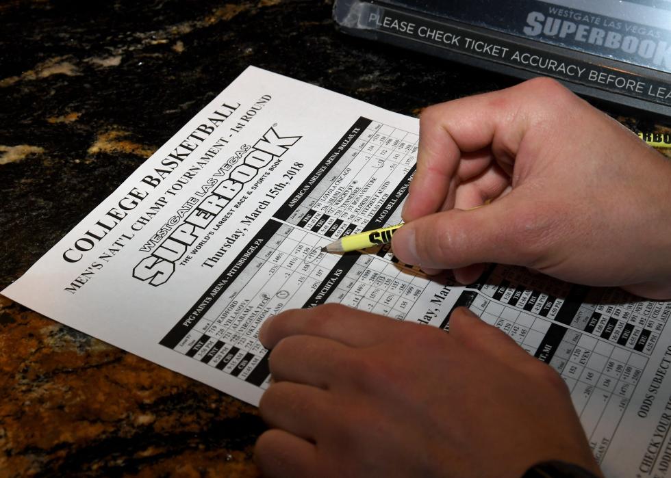 Man makes bets during a viewing party for March Madness