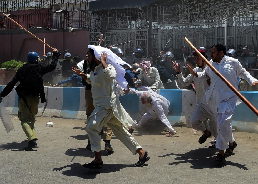 Activists run from policemen during a protest