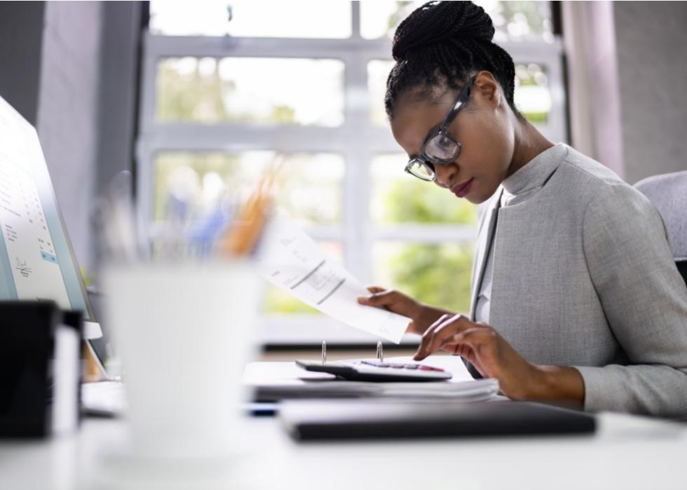 Female accountant typing on a calculator.