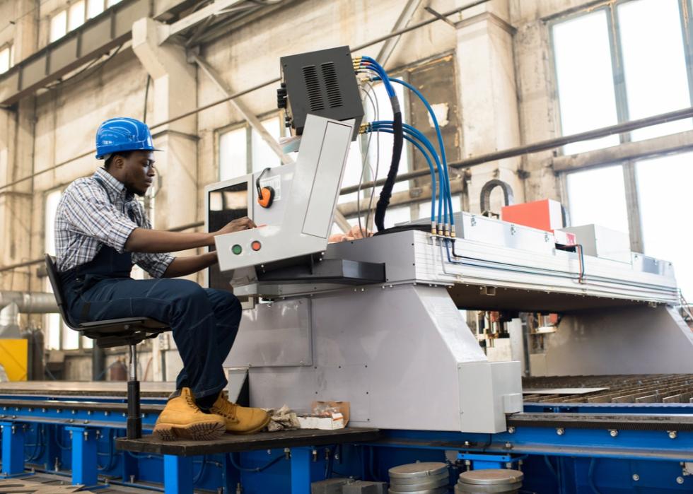 Male worker operating a machine in a factory.