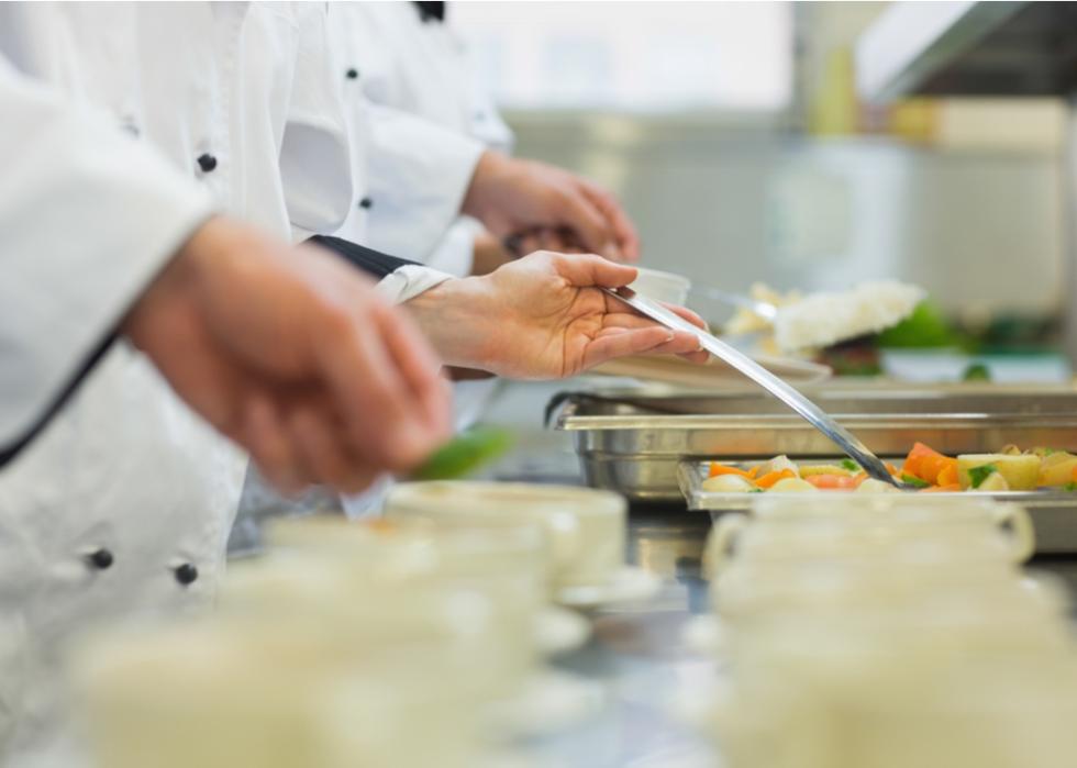 Chefs in a row serving food.