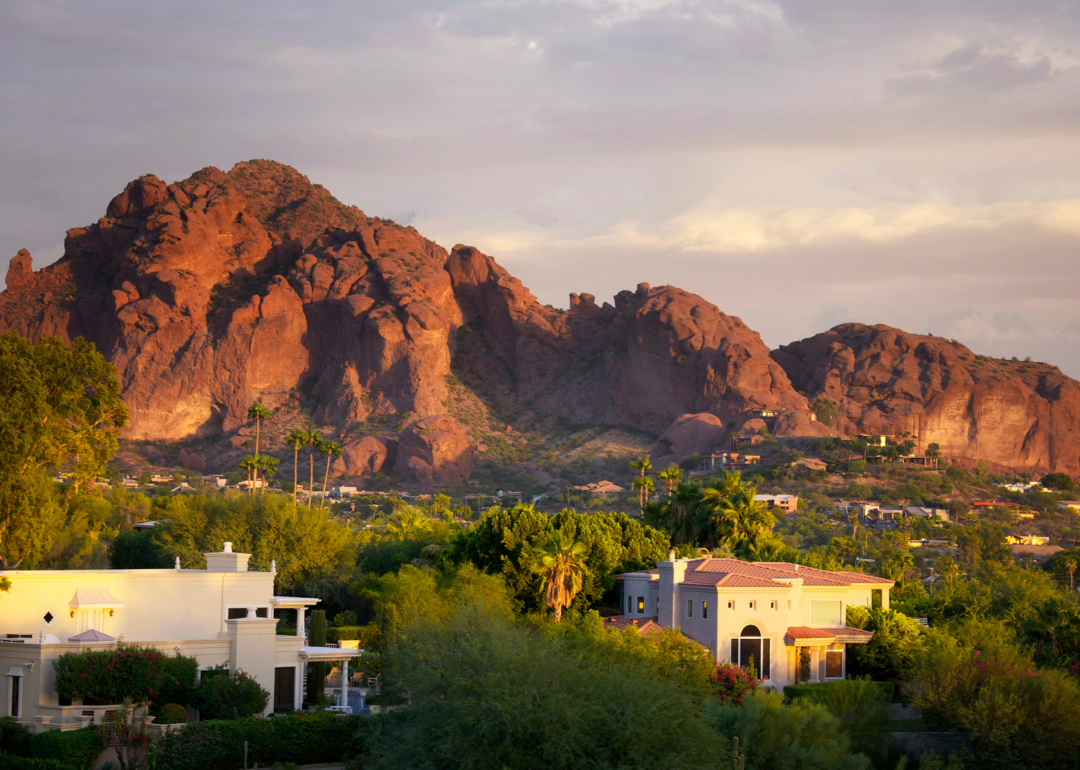 Large stucco homes in the hills with a mountain in the background.