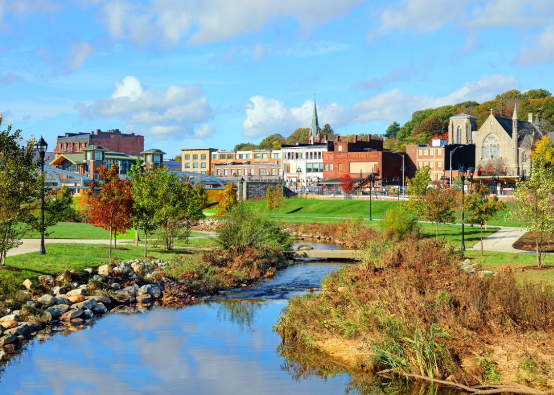 A winding stream flowing around historic buildings in Meriden.