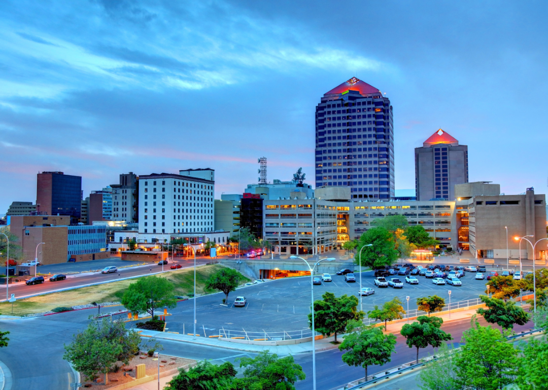 A large parking lot in front of buildings in downtown Albuquerque.