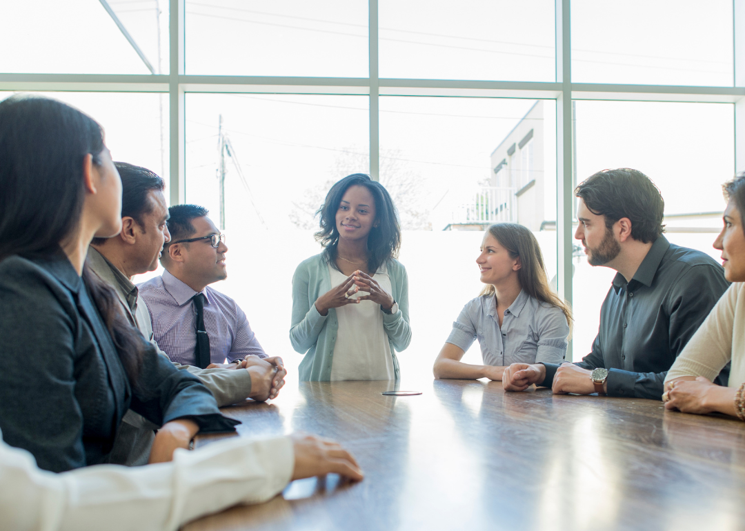 A group of people sit at a table having a meeting.