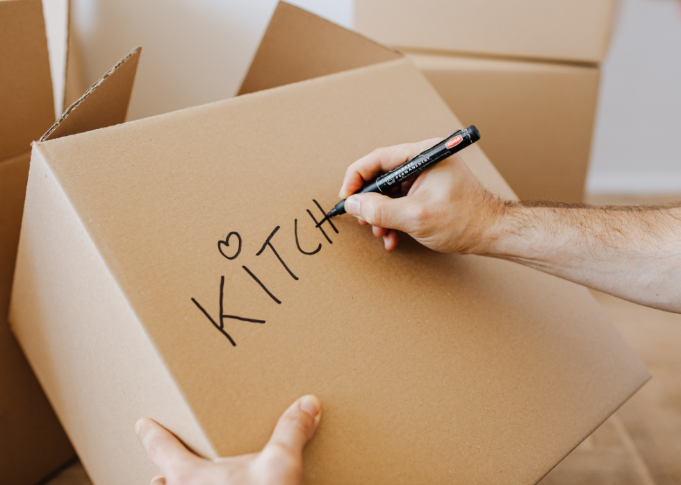 Labeling a kitchen box for moving.
