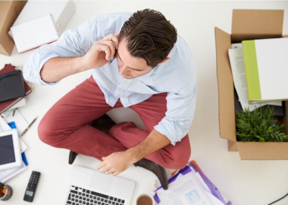 Overhead shot of man on his phone surrounded by boxes.