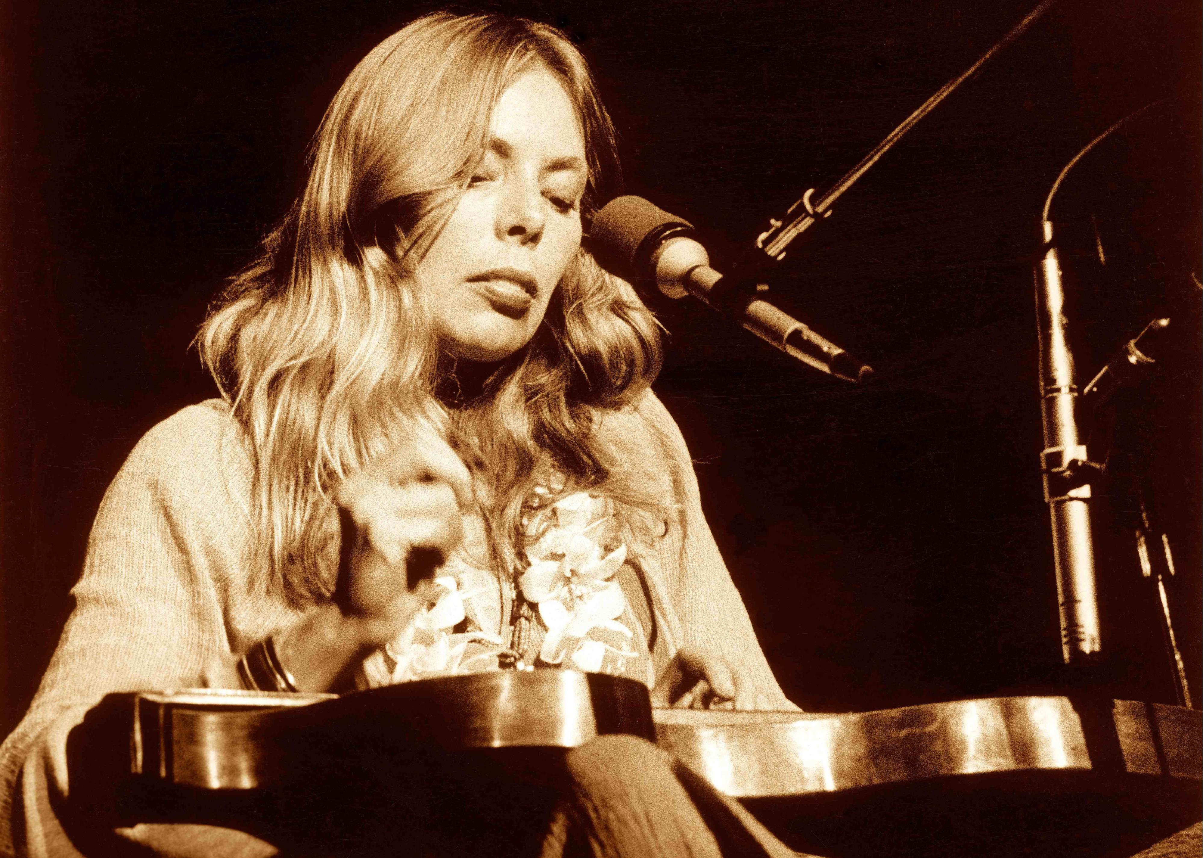 Joni Mitchell performing onstage.