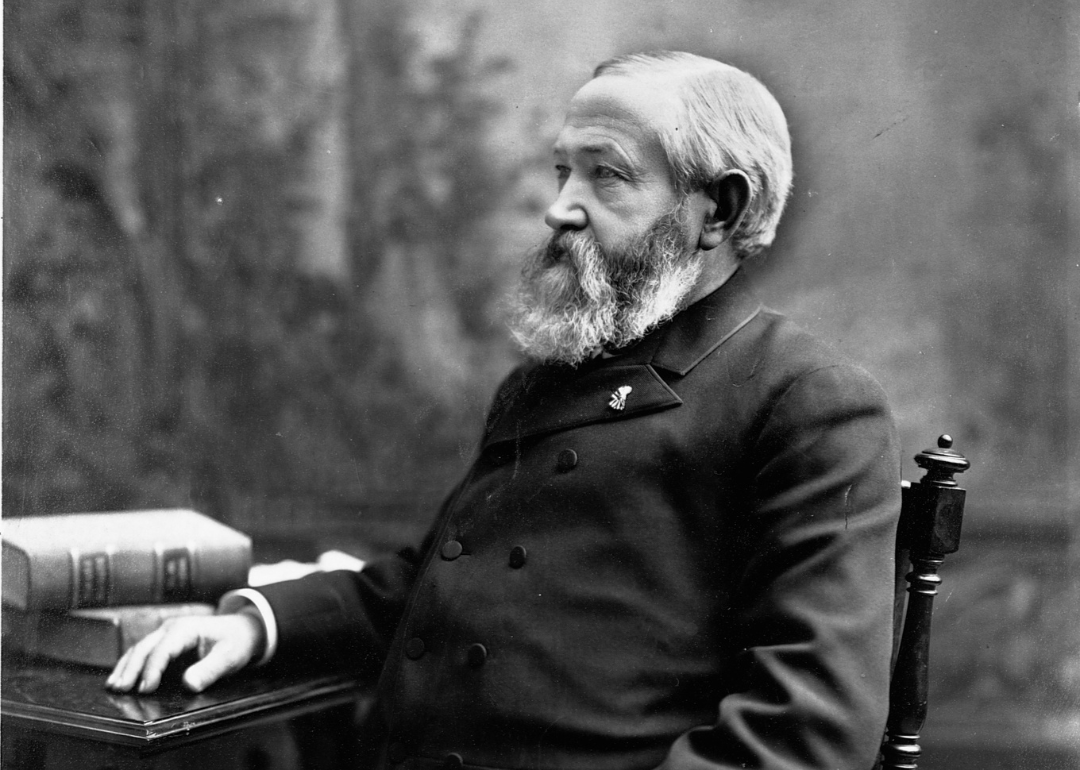 Benjamin Harrison sitting at a desk in a dark suit.