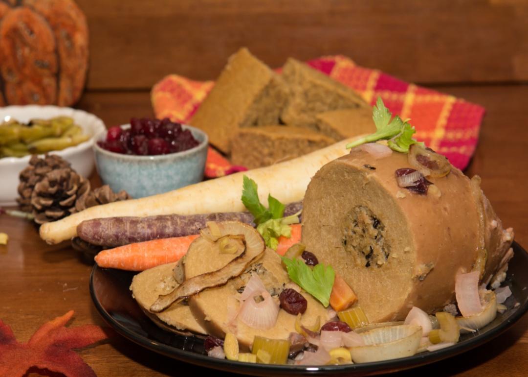 A plate with stuffed tofu turkey surrounded by vegetables.