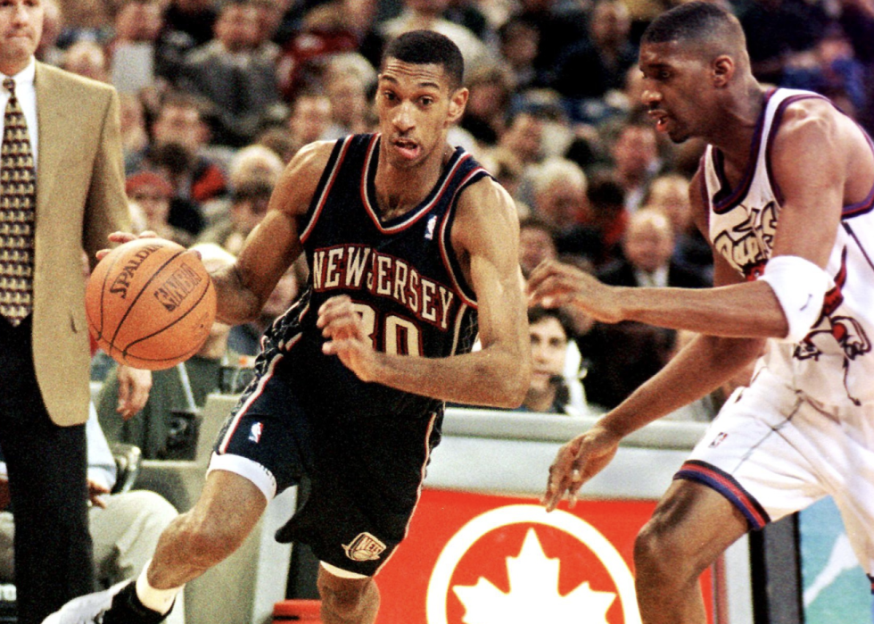 New Jersey Nets' Kerry Kittles dribbles the ball around Toronto Raptor Tracy McGrady.