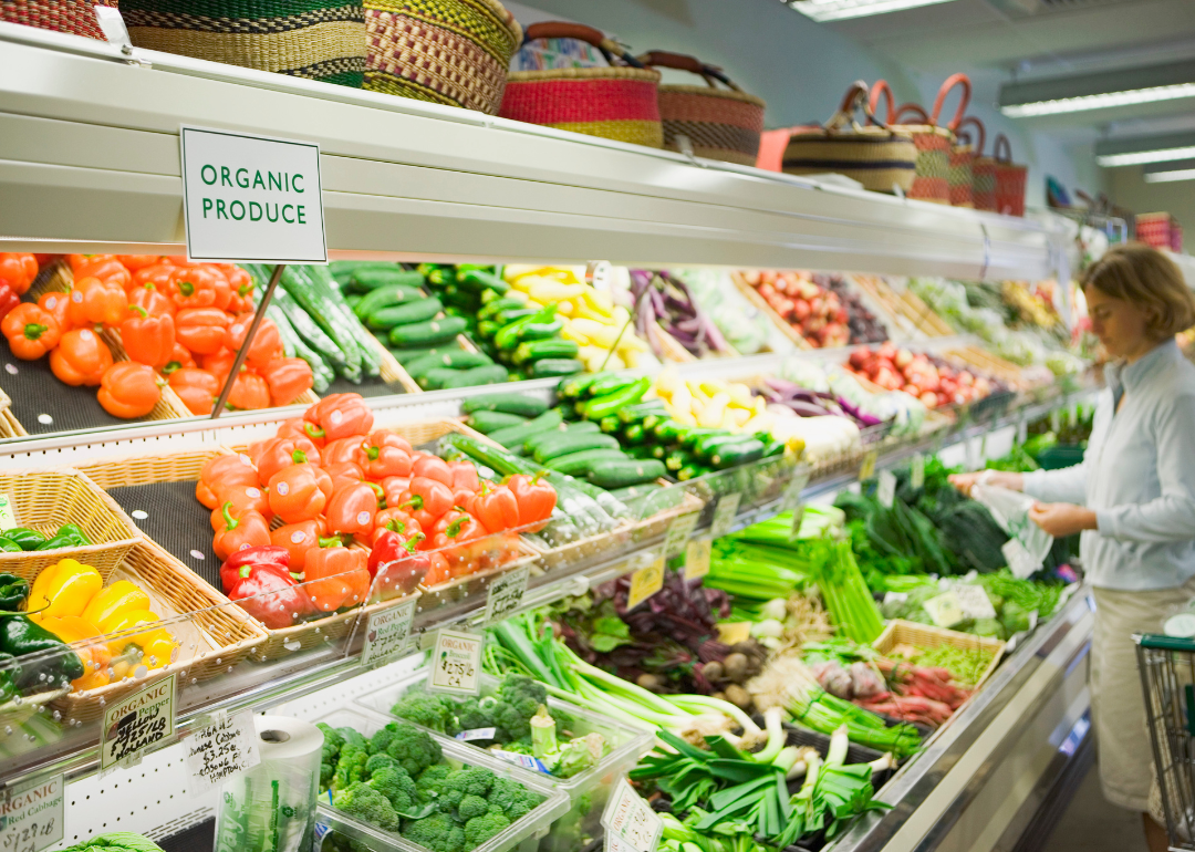 A woman browsing the organic produce section of the grocery store.