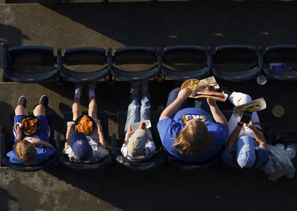 A family eating food in a stadium.