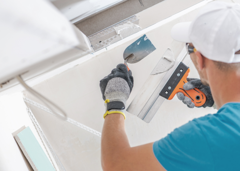 A man building a drywall ceiling.